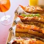 Lobster roll Mason's servito insieme a un cocktail