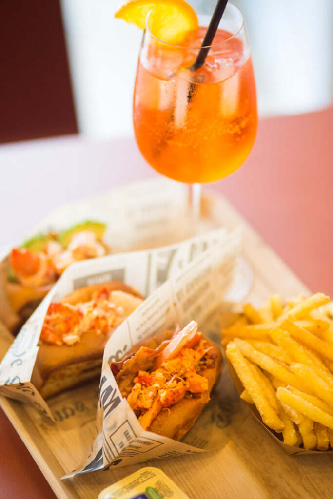 Lobster roll Mason's con patatine fritte e uno spritz sul tavolo